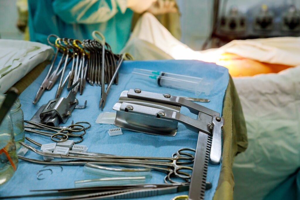 Surgical tools lying table of surgeons at work operating in surgical theatre